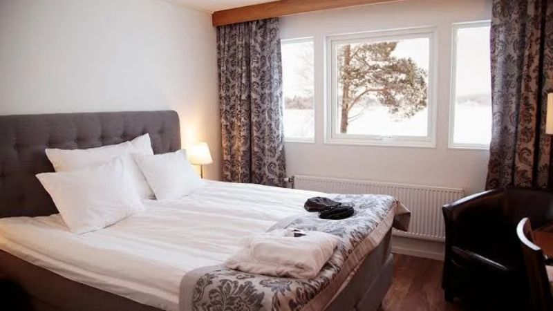 Hotellrum p� Kraja Hotell i Arjeplog med dubbels�ng, elegant inredning, stora f�nster med utsikt mot naturen och bekv�mligheter f�r en avkopplande vistelse i Lappland.